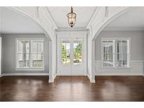 Bright foyer boasts hardwood floors, gray walls, and elegant double doors leading to the outdoors at 4035 Pinebrook Cir, Cumming, GA 30028