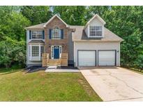 Charming two-story home features a brick and siding exterior with a two-car garage and well-manicured lawn at 4148 Kings Cswy, Ellenwood, GA 30294