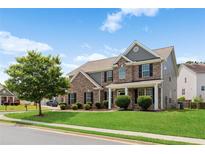 Charming two-story home with brick and gray siding, landscaped lawn, and inviting front porch at 3366 Bridge Walk Dr, Lawrenceville, GA 30044
