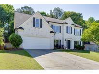 Charming two-story home with painted brick, black shutters, well-manicured lawn, and attached two-car garage at 1755 Waters Ferry Dr, Lawrenceville, GA 30043