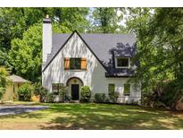 Charming white brick home featuring a steep roofline and mature landscaping at 2554 Saint Patrick Se St, Atlanta, GA 30317