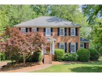 Charming brick home with black shutters, mature trees, and well-manicured landscaping at 3625 Stonehenge Ne Way, Marietta, GA 30066