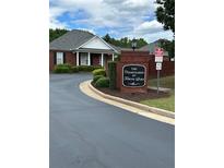 Welcoming entrance to the Courtyards at Towne Lake with well-maintained landscaping and brick signage at 401 Courtyard Ter, Woodstock, GA 30189