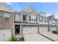 Attractive townhome showcases stone accents, gray siding, and attached two car garage at 5365 Radford Loop, Fairburn, GA 30213