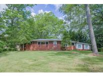 Charming single-story brick home surrounded by mature trees and a spacious front yard at 2279 Parkview Cir, College Park, GA 30337