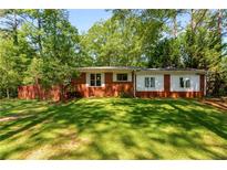 Charming brick home with lush green lawn and mature trees providing shade at 2279 Parkview Cir, College Park, GA 30337
