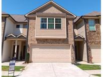 Two-story townhome boasts brick and siding, with a garage and well-maintained lawn at 101 Dewey Rd, Lilburn, GA 30047