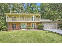 Charming two-story home with a brick facade, upper porch, and a well-manicured lawn at 1080 Northshore Dr, Roswell, GA 30076