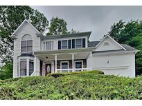 Charming two-story home with a covered front porch and well-maintained landscaping at 2001 Fairbrook Ln, Woodstock, GA 30189