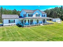 Beautiful two-story home with a large manicured lawn and a charming covered front porch at 1621 Dixie Rd, Covington, GA 30014