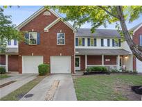 Charming townhome featuring brick facade, complemented by blue shutters and a well-manicured lawn at 210 Cottonwood Creek Cir, Canton, GA 30114
