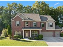 Beautiful two-story brick home with a well-manicured lawn and attached two car garage at 211 Parc Dr, Canton, GA 30114