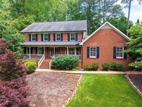 Charming two-story brick home with a welcoming front porch and well-manicured landscaping at 4930 Forestglade Ct, Tucker, GA 30087
