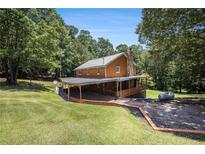 Charming home boasts a metal roof and covered veranda, nestled in a lush landscape at 1795 Hutcheson Ferry Rd, Whitesburg, GA 30185
