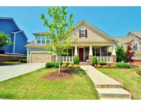 Charming home with a well-manicured lawn, lovely landscaping, and a welcoming front porch at 1005 Woodbury Rd, Canton, GA 30114