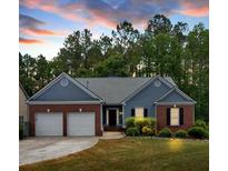 Charming one-story home featuring a well-manicured lawn and mature trees, with a two-car garage and inviting entry at 10 Bayberry Ct, Acworth, GA 30101