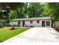 Charming single-story home features a well-manicured lawn and a concrete driveway at 1819 Waldrep Se Cir, Marietta, GA 30060