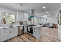 Bright kitchen with white cabinetry, stainless steel appliances, and eat-in bar overlooking the open concept living space at 1819 Waldrep Se Cir, Marietta, GA 30060