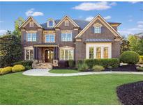 A stately brick home featuring manicured landscaping, detailed architectural elements, and a welcoming entryway at 2325 Manor Creek Ct, Cumming, GA 30041