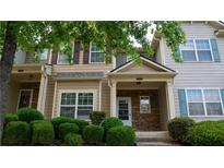 Inviting townhome showcasing charming exteriors and well-manicured landscaping, complete with a stone-accented entryway at 2476 Suwanee Pointe Dr, Lawrenceville, GA 30043