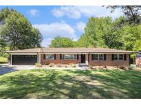Charming brick home with an attached garage, well-manicured lawn, and mature trees at 201 E Simon Nw Ter, Atlanta, GA 30318