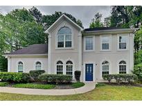 Charming two-story home boasts a well-maintained lawn and landscaped yard with a welcoming blue front door at 2312 Mahogany Glen Pl, Lawrenceville, GA 30043