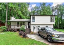 Charming two-story home with a covered front porch, manicured lawn, and a driveway with parking at 5006 Dekalb Way, Stone Mountain, GA 30087