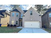 Charming two-story brick home with attached two-car garage and manicured front yard at 265 Sanctuary Dr, Lawrenceville, GA 30046