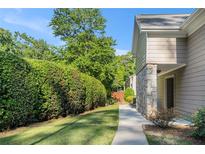 Inviting home exterior with stone accents, sidewalk, grassy area and lush landscaping at 502 Brighton Pt, Atlanta, GA 30328