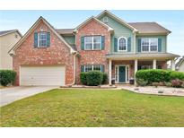 Charming two-story home features a brick facade, manicured lawn, and a welcoming front porch at 973 Buckhorn Bnd, Locust Grove, GA 30248