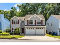 Charming two-story home featuring a two-car garage and gray siding, offering a welcoming curb appeal at 3504 Benthollow Ln, Duluth, GA 30096