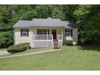 Charming single-story home featuring a front porch, well-maintained lawn, and mature trees providing shade and curb appeal at 213 Johnstons Dr, Dallas, GA 30157