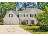 Charming two-story home featuring a well-manicured lawn, a two-car garage, and a classic white facade at 1018 Layfield Ct, Dunwoody, GA 30338
