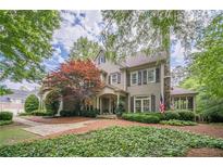 Charming two-story home with beautiful landscaping and an inviting covered front porch at 5650 Buckleigh Pointe, Suwanee, GA 30024