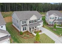 Two-story home boasts a well-manicured lawn, neutral colors, and a classic architectural design at 6100 Misty Hill Ln, Buford, GA 30518