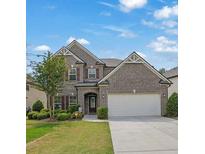 Charming two-story brick home with a well-manicured lawn and attached two car garage at 4050 Pleasant Woods Dr, Cumming, GA 30028