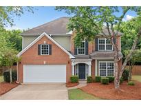 Charming brick two-story home with a manicured lawn, two car garage and mature trees at 508 Canton Ct, Canton, GA 30115