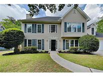 Charming two-story home featuring a well-manicured lawn, inviting front door, and symmetrical window design at 1311 Bustling Sw Ln, Marietta, GA 30064