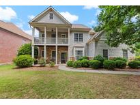 Charming two-story home with a welcoming front porch, stone accents, and lush landscaping at 944 Hidden Falls Se Ln, Smyrna, GA 30082