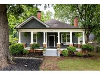Charming home featuring a covered front porch with columns, brick accents, and mature landscaping at 230 Milton Se Ave, Atlanta, GA 30315