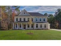 Beautiful two-story brick home with a covered porch and lush green lawn at 76 Homesite Dulles Dr, Mcdonough, GA 30253