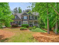 Charming two-story home featuring mature landscaping and a welcoming front porch at 1100 Lady Slipper Way, Canton, GA 30115