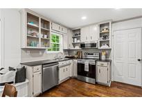 Well-lit kitchen with stainless steel appliances, hardwood floors, and bright window at 1320 Country Acres Ln, Lawrenceville, GA 30045