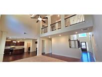 Bright living room with hardwood floors, high ceilings, open concept, and an adjacent kitchen at 5010 Lynnonhall Ct, Stonecrest, GA 30038