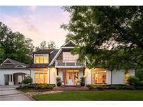 Charming two-story home with a brick walkway, white facade, and balcony against a colorful sunset at 5360 Lake Forrest Dr, Atlanta, GA 30342