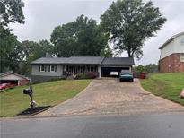 Charming single Gathering home with a well manicured lawn, long driveway and attached garage at 2298 Hillbriar Dr, Buford, GA 30518