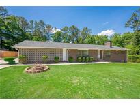 Charming brick home featuring a manicured lawn and unique architectural details at 2133 Bird Ln, Snellville, GA 30078