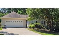 Charming home featuring an attached two car garage, traditional curb appeal, and a well-manicured lawn at 239 Clear Brook Trl, Douglasville, GA 30134