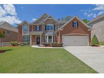 Charming two-story home with brick and stone accents, manicured lawn and a two car garage at 4100 Secret Shoals Way, Buford, GA 30518