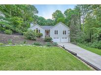 Charming home with a well-manicured lawn, a two-car garage, and mature landscaping at 507 Falls Way, Woodstock, GA 30188